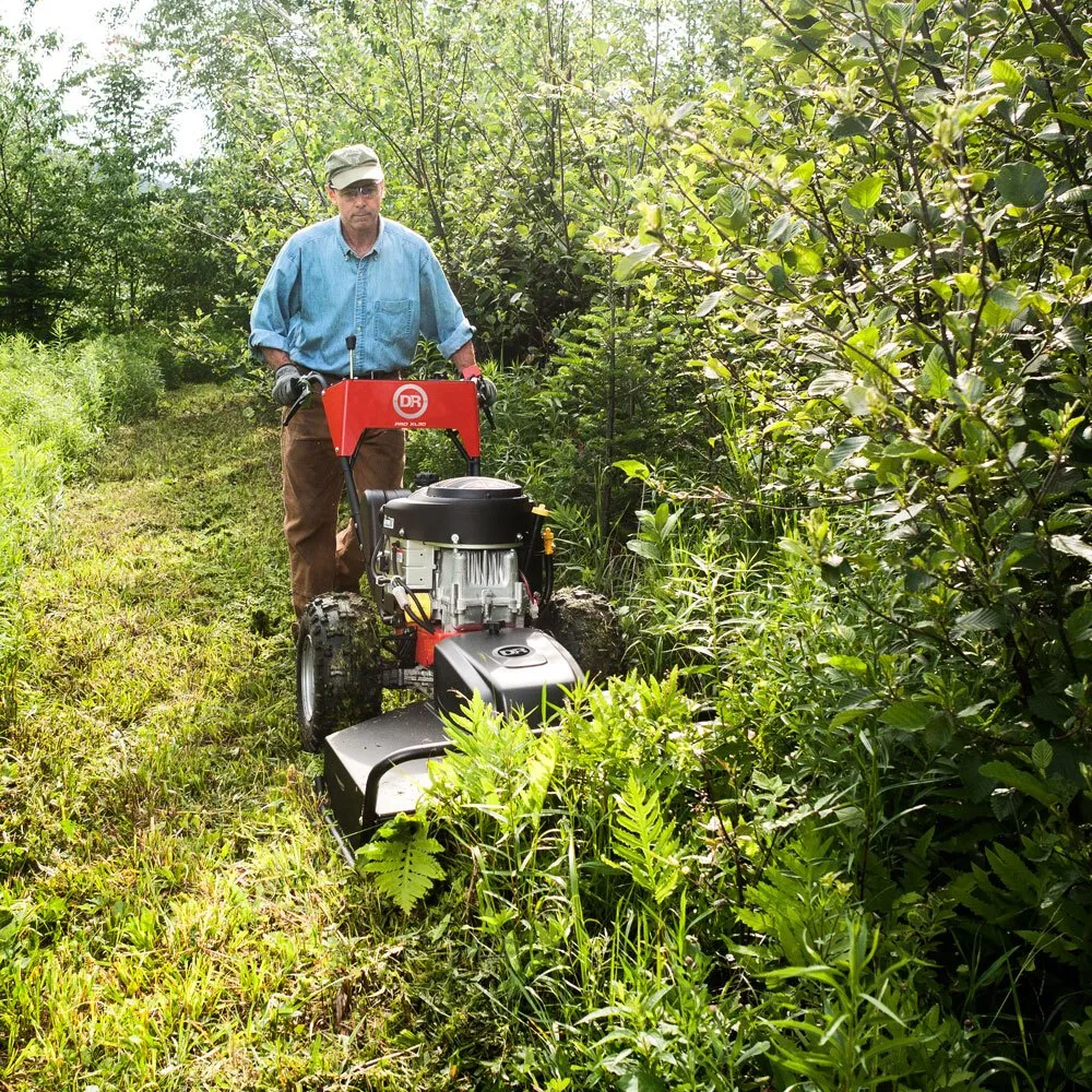 The brush mower cutting a path through dense standing brush